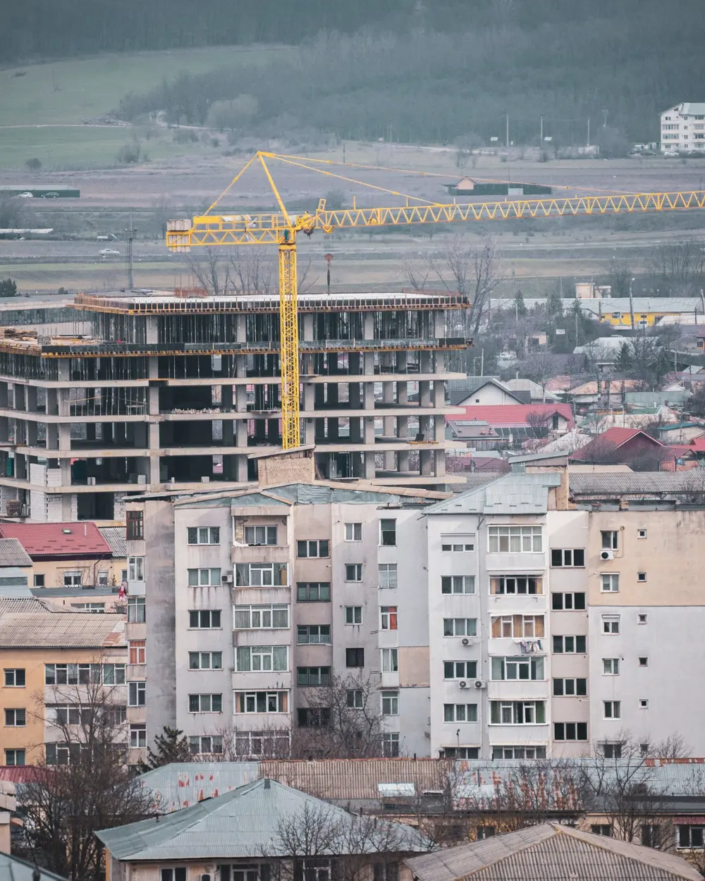 Cadru de beton și macara deasupra orașului