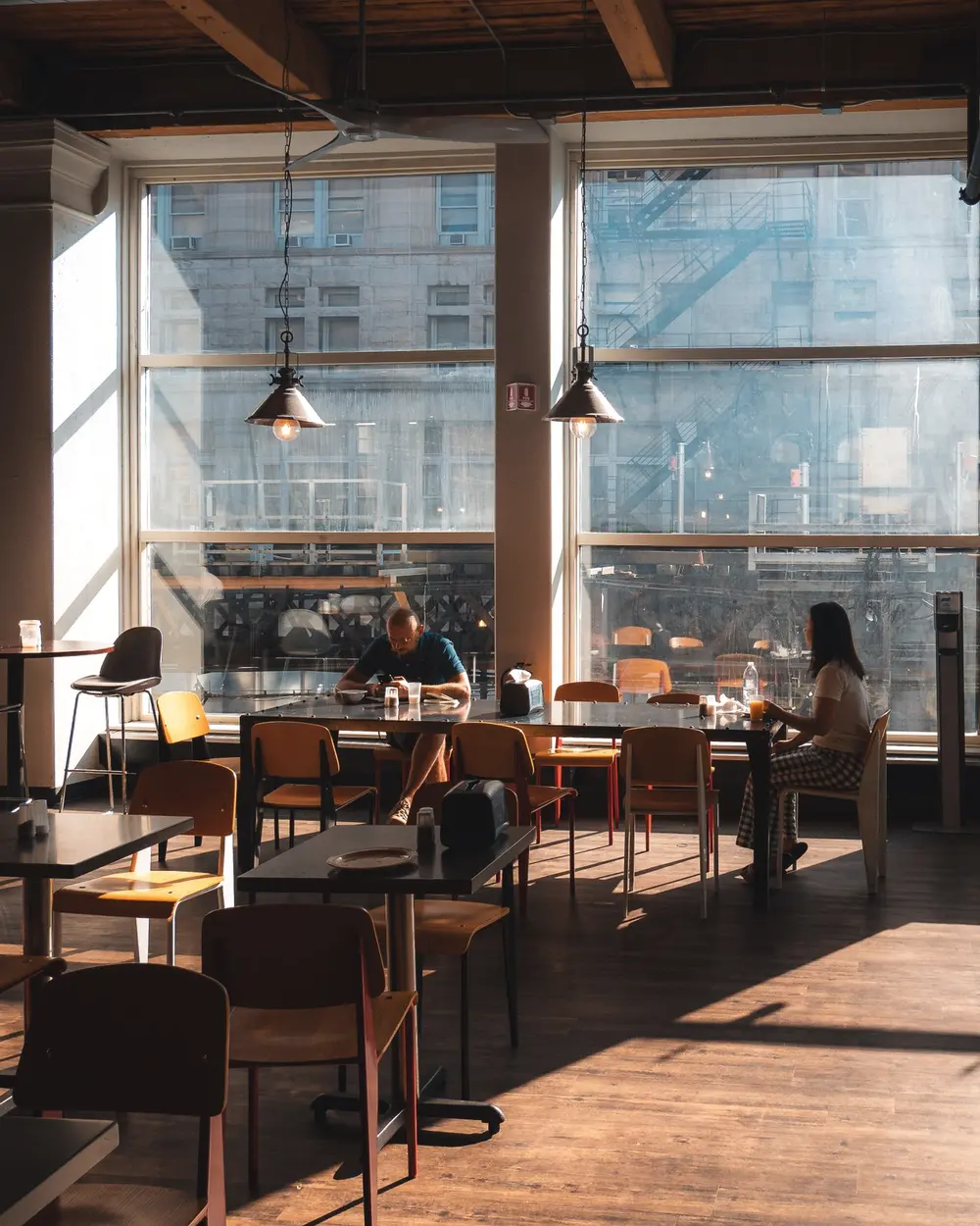 Cafenea luminoasă într-o clădire reconvertită, cu clienți