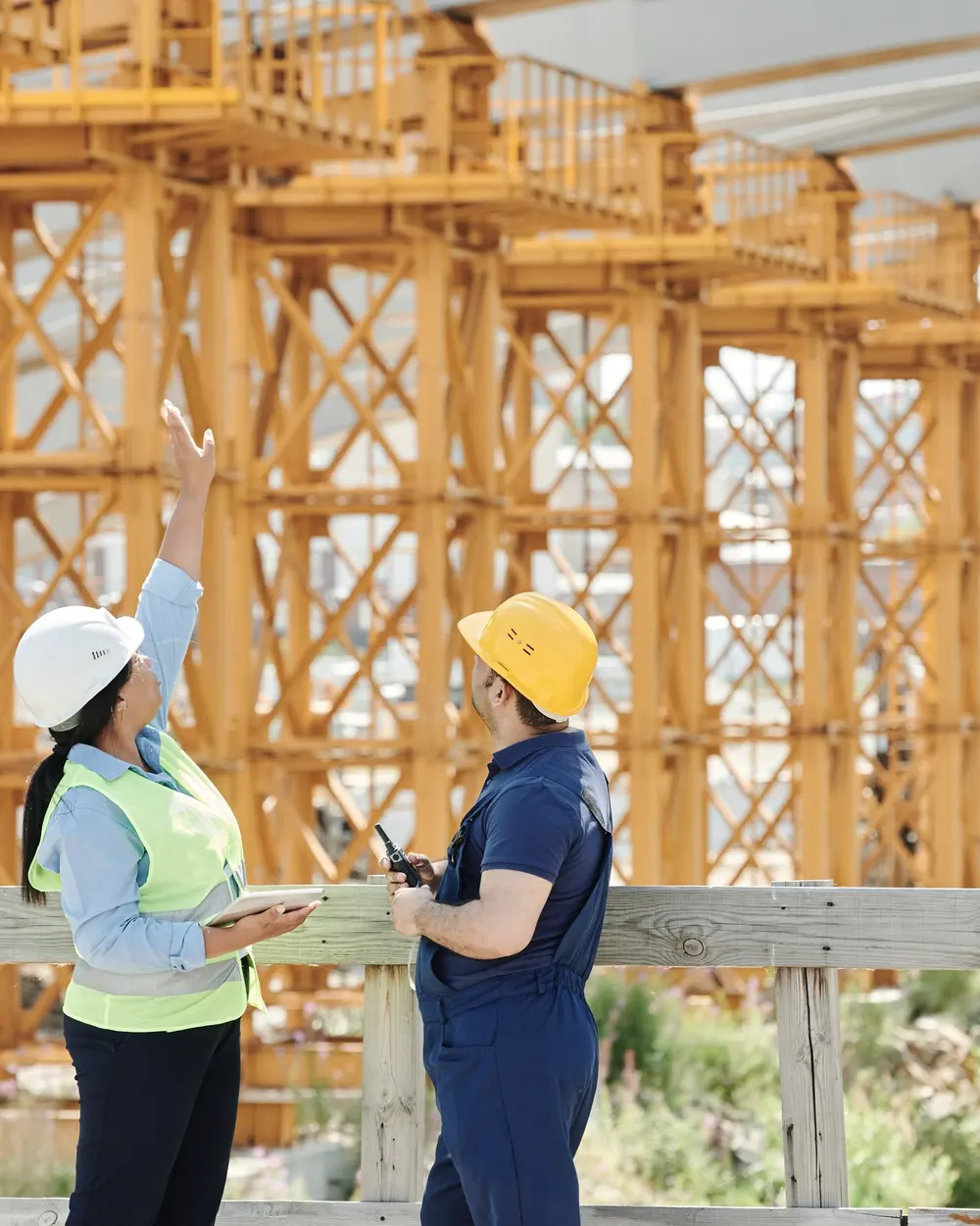Ingineri pe șantier care arată spre structură